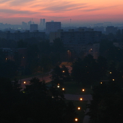 A park with street lamps before sunrise, city center on the background