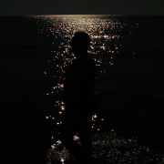 A silhouette in front suns reflection on the see